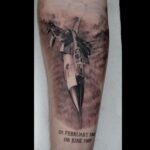 Black and grey realistic flying jet tattoo